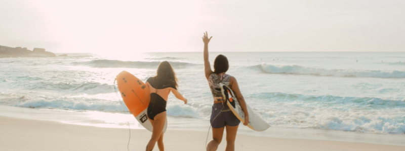 Two Women enjoying the surf on an ocean beachline.