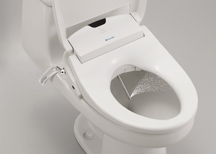 Bidet toilet seat extended nozzle positioning
